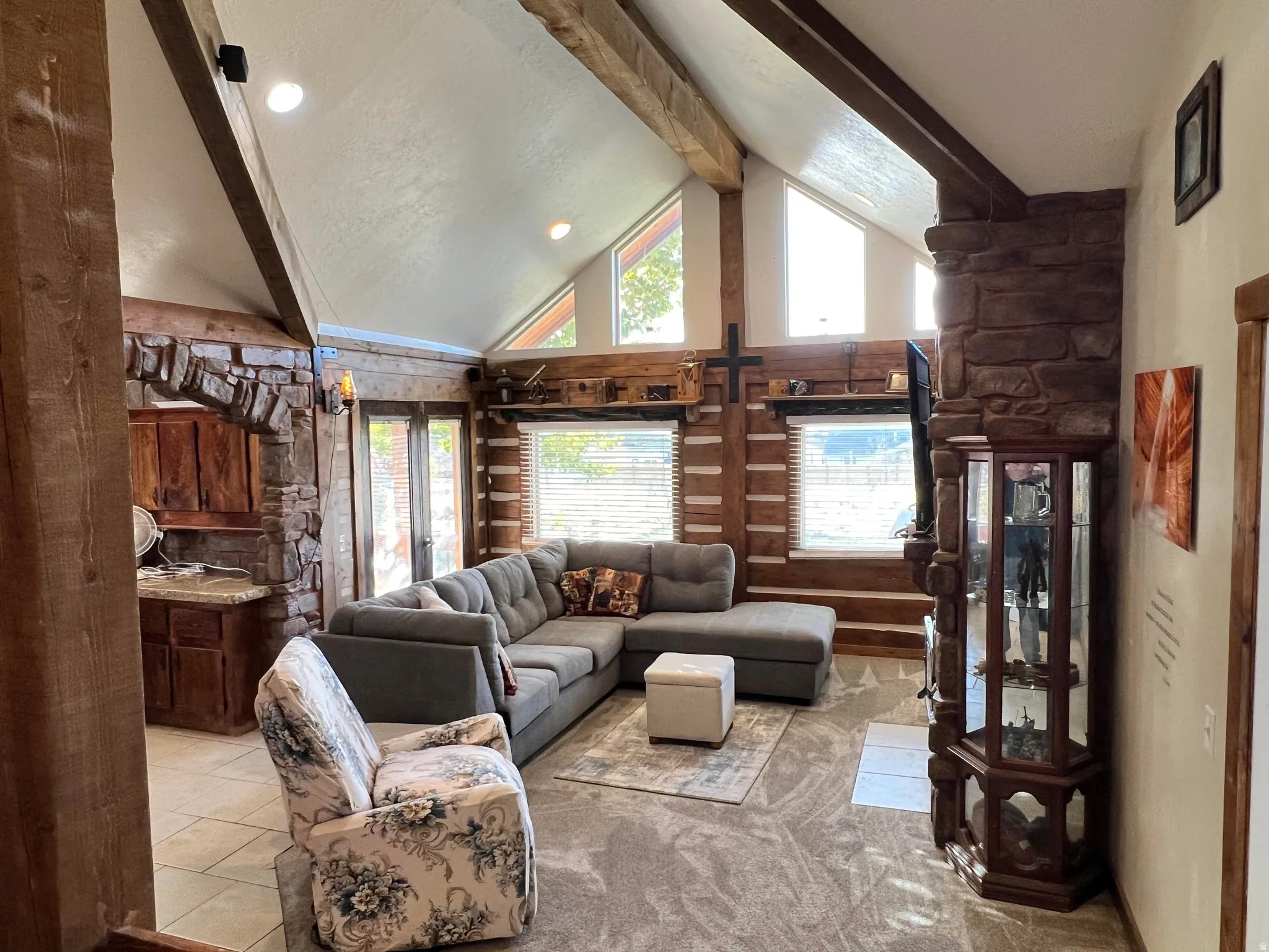 Living area featuring beamed ceiling, high vaulted ceiling, light colored carpet, and recessed lighting