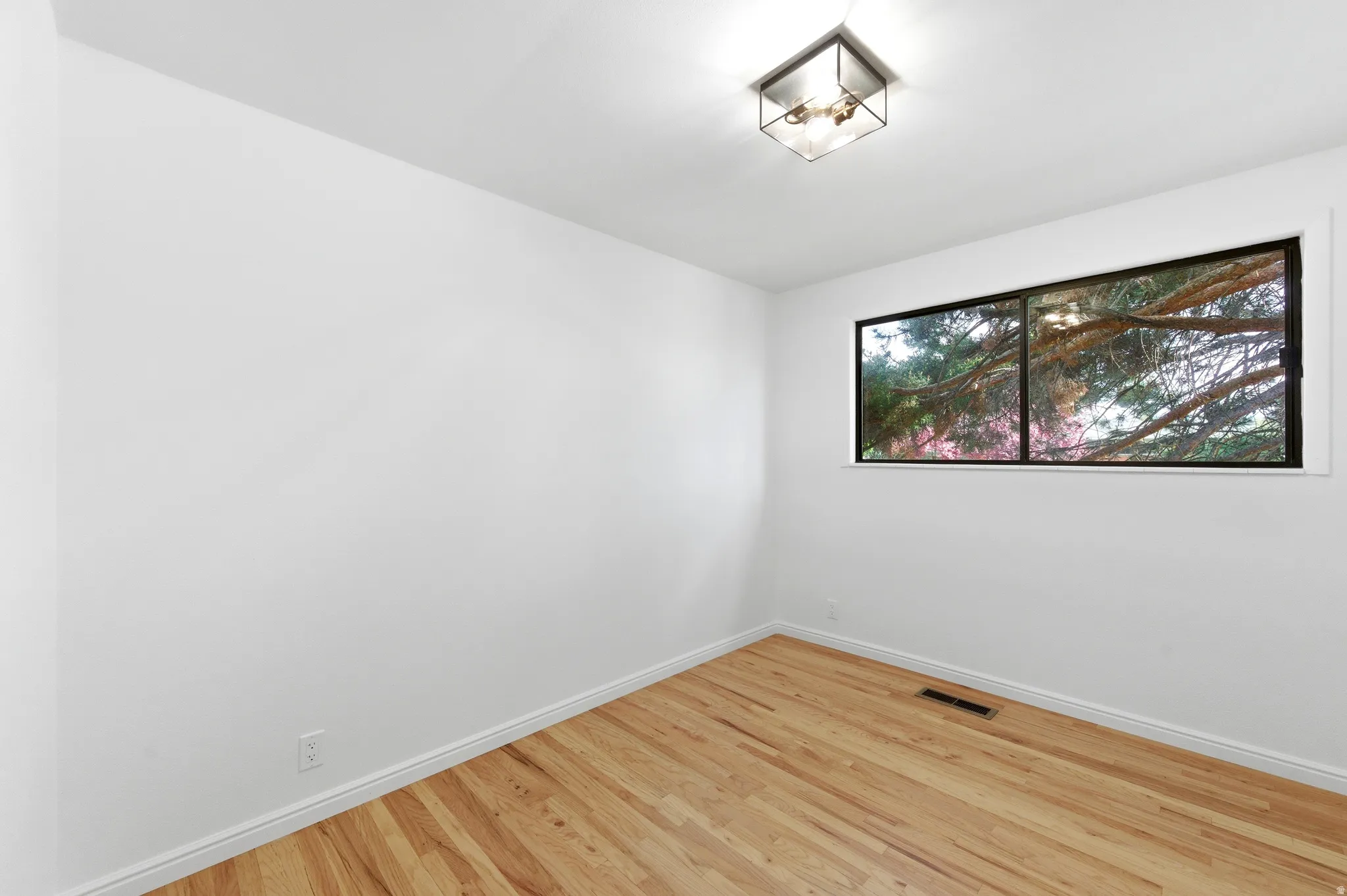 Empty room with light wood-style flooring and baseboards