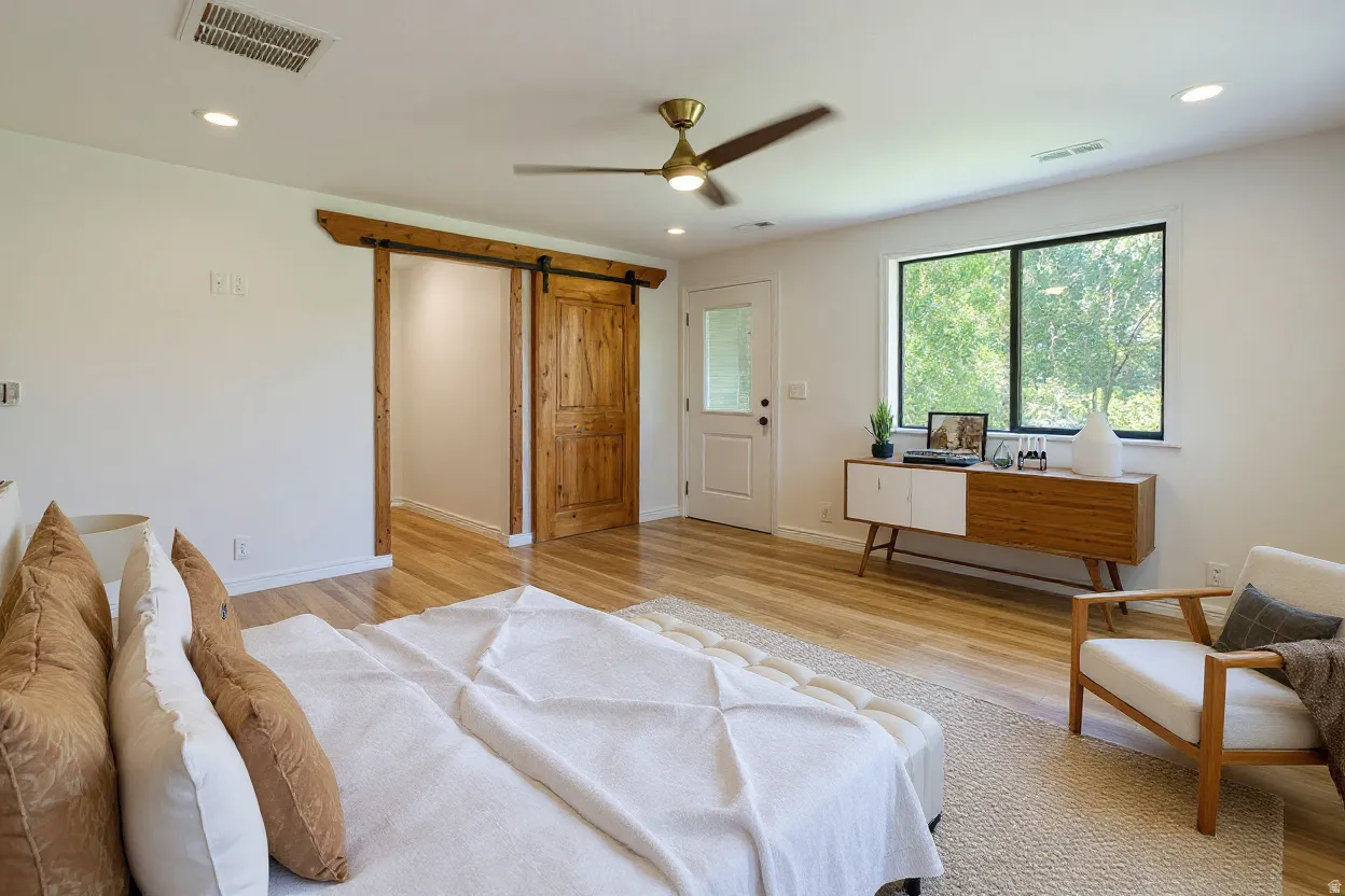 Spacious room featuring wood-finish flooring, a contemporary ceiling fan, recessed lighting, and a window with black trim