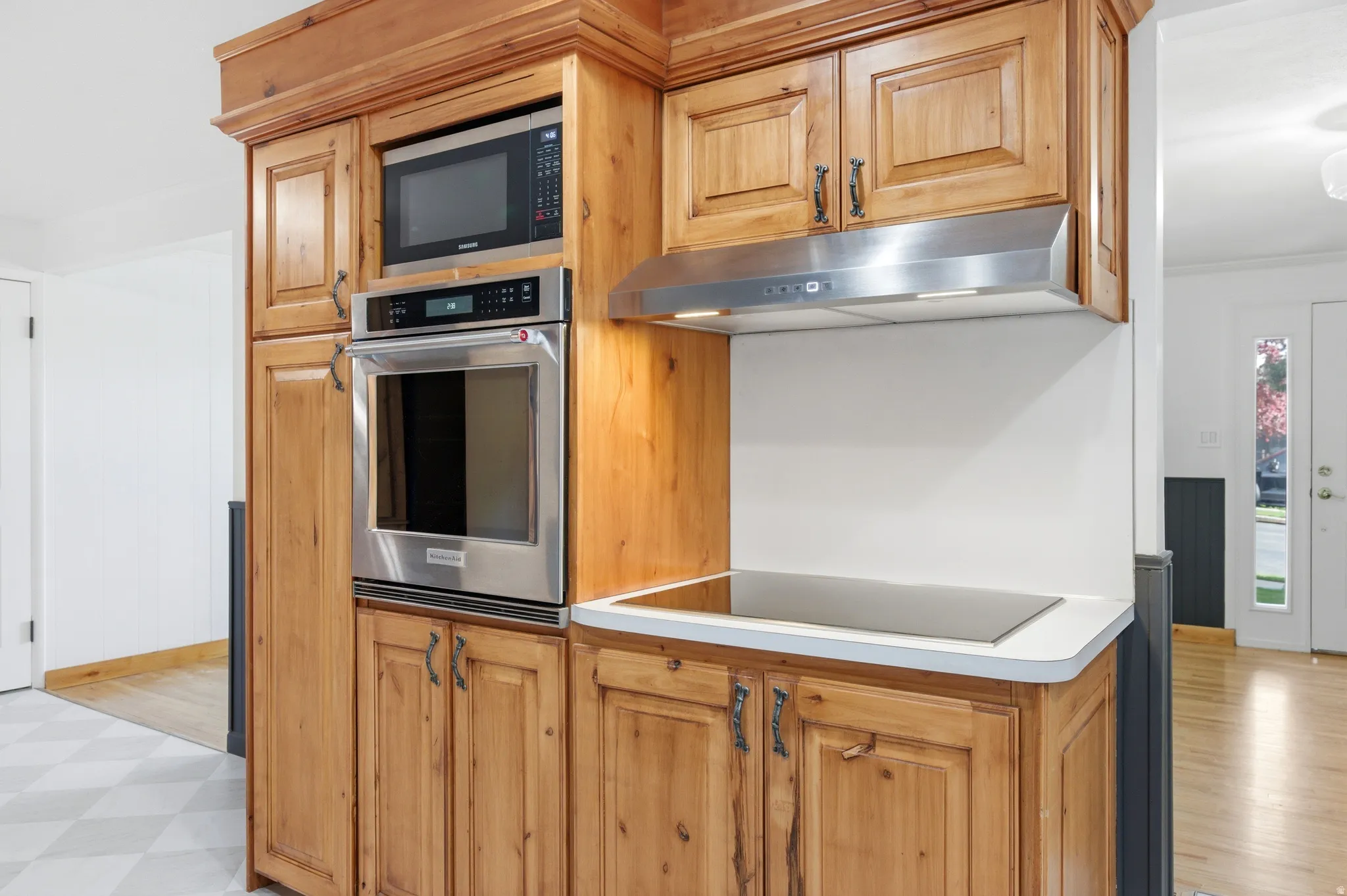Kitchen featuring stainless steel appliances, light countertops, light flooring, and wood finish cabinetry