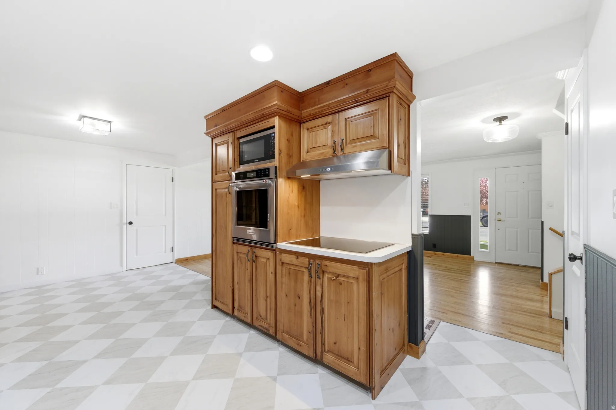 Kitchen with light flooring, black appliances, and wood finish cabinetry