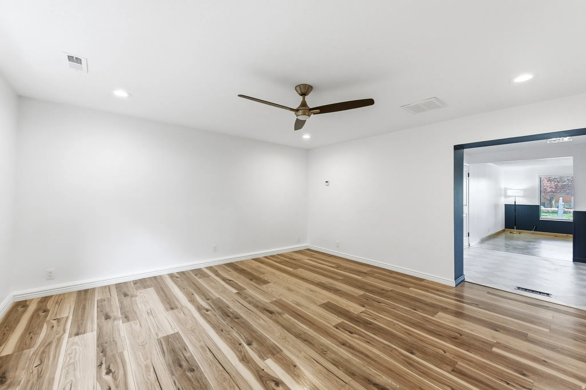 Spare room featuring light wood-type flooring, ceiling fan, and recessed lighting