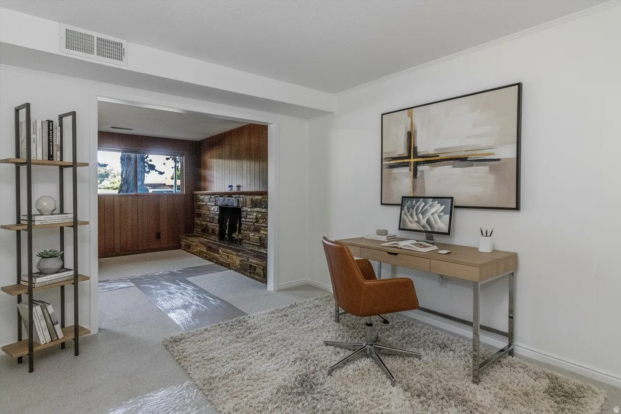 Versatile room with white wall finishes, a broad doorway, and a stone-clad fireplace visible in the background