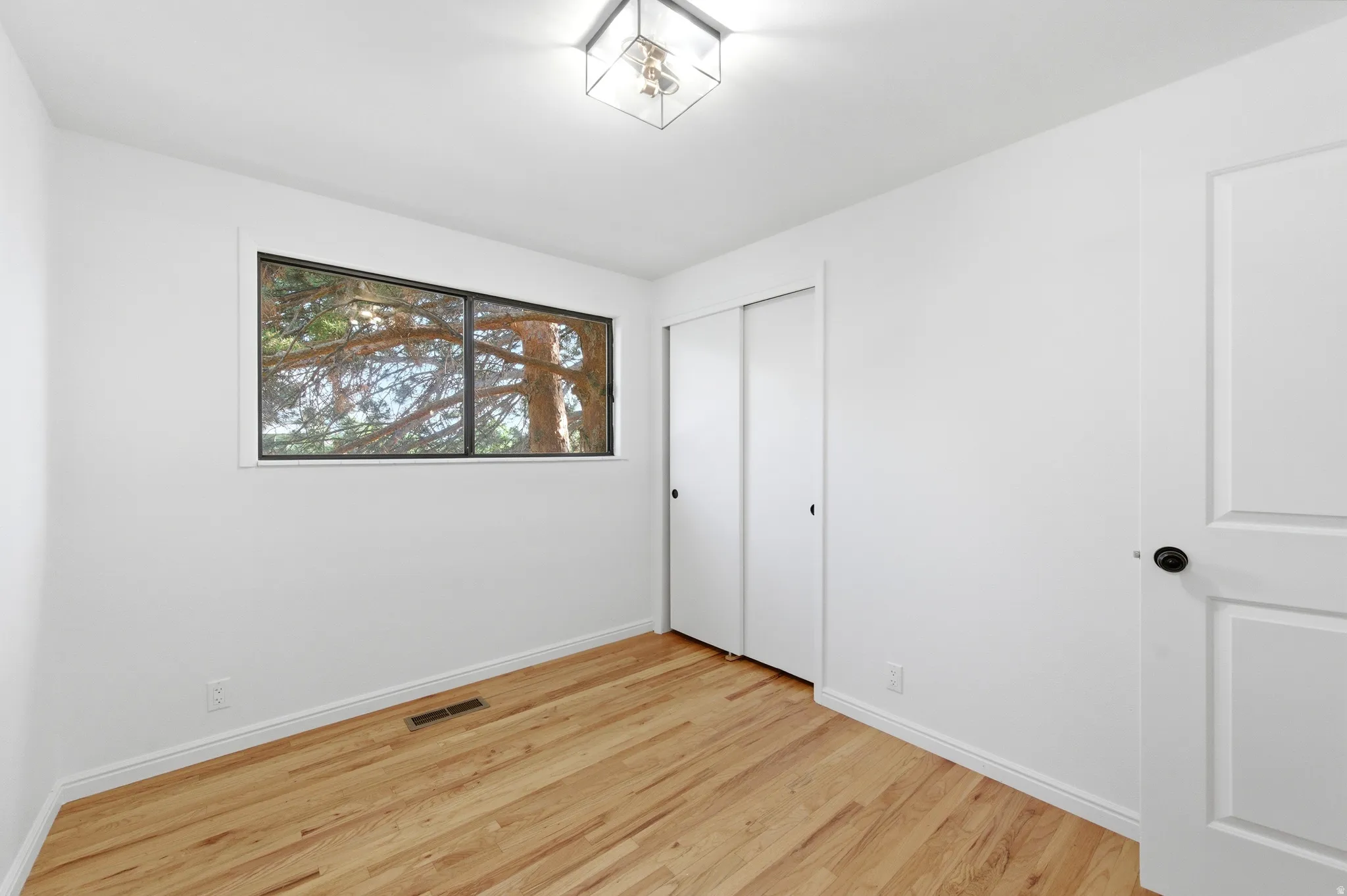 Unfurnished bedroom featuring light wood-type flooring and a closet