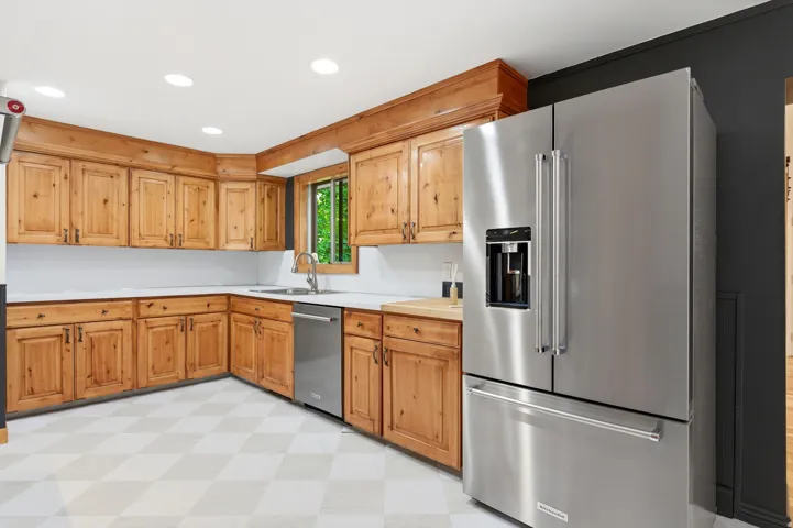 Kitchen featuring light flooring, light countertops, stainless steel appliances, recessed lighting, and wood finish cabinets
