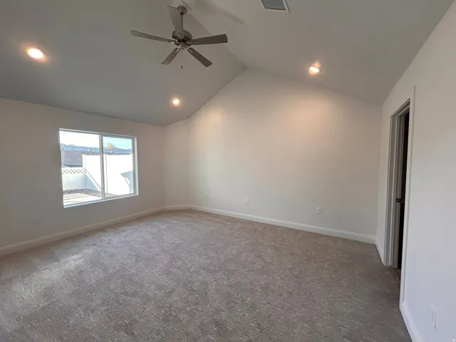 Carpeted empty room with high vaulted ceiling, recessed lighting, and ceiling fan