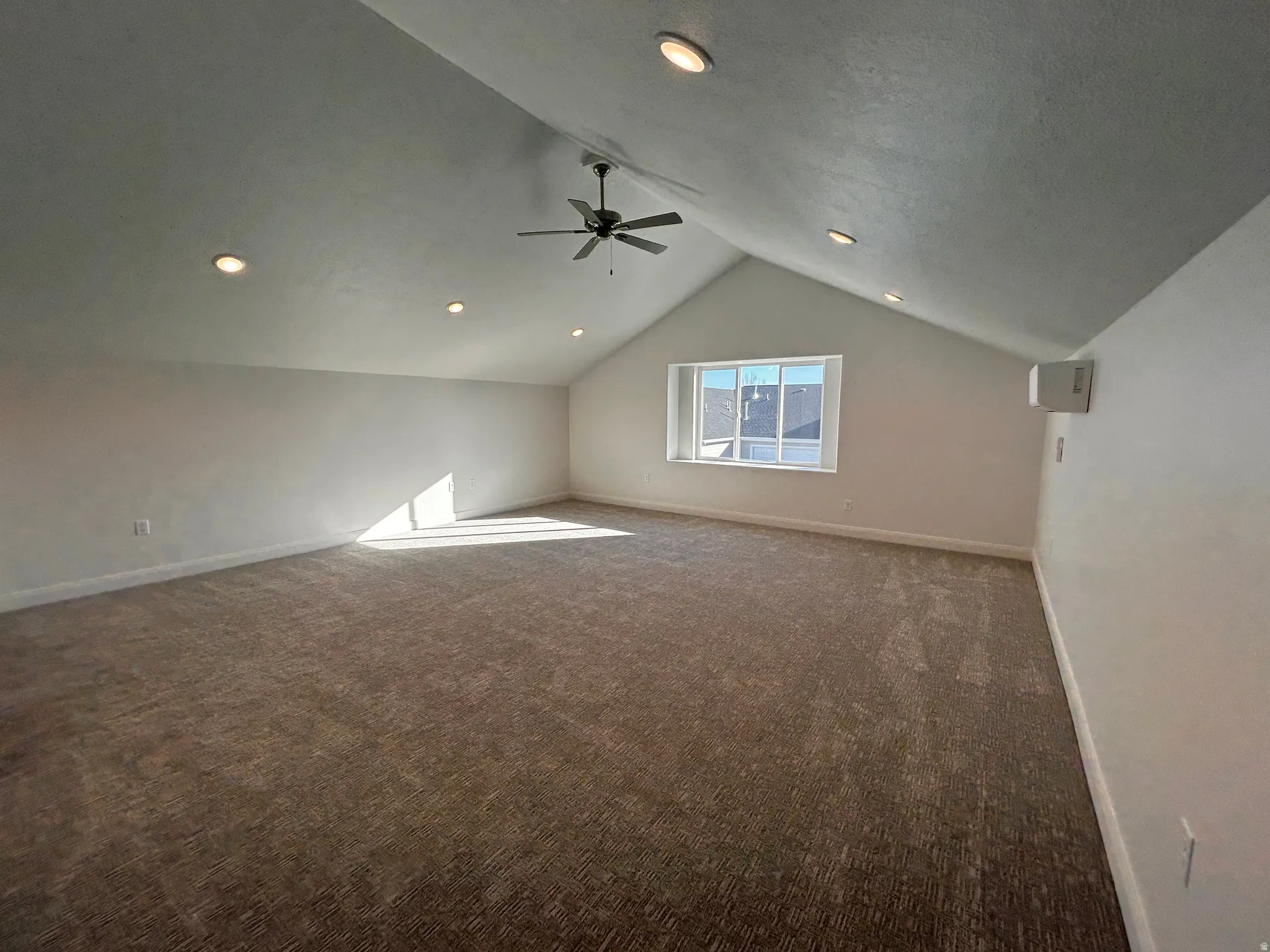 Bonus room with dark carpet, vaulted ceiling, a ceiling fan, and recessed lighting