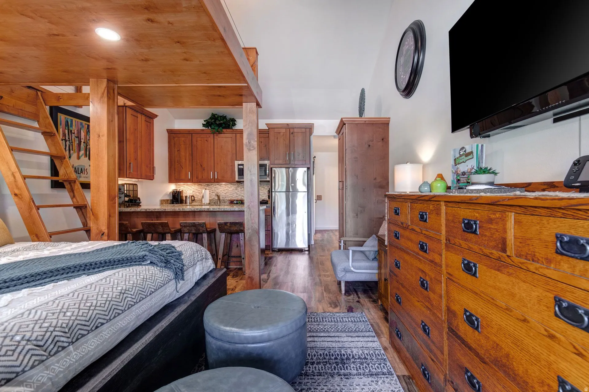 Bedroom with dark wood finished floors, freestanding refrigerator, wood ceiling, and recessed lighting