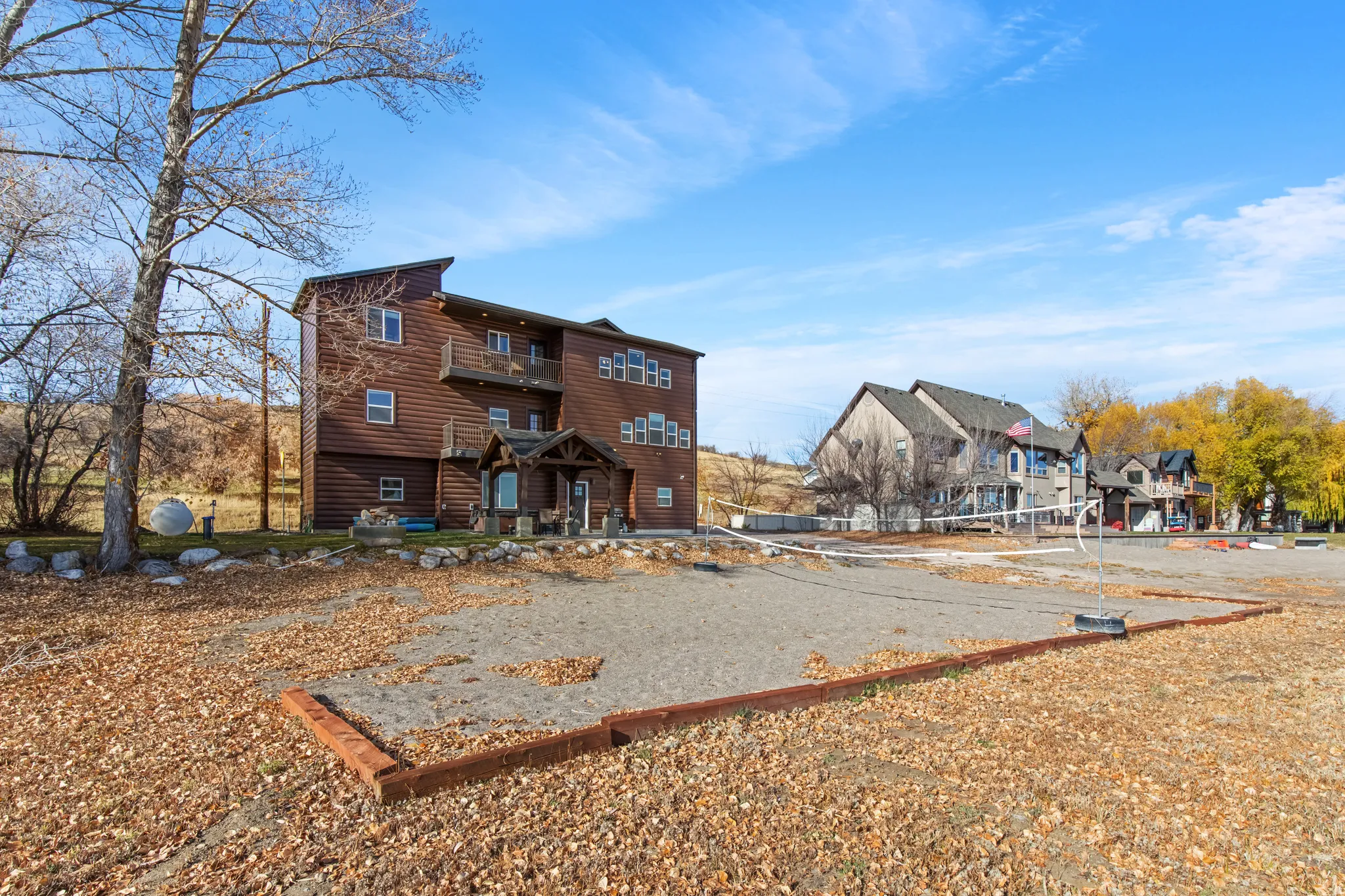Rear view of property featuring volleyball court and a patio area