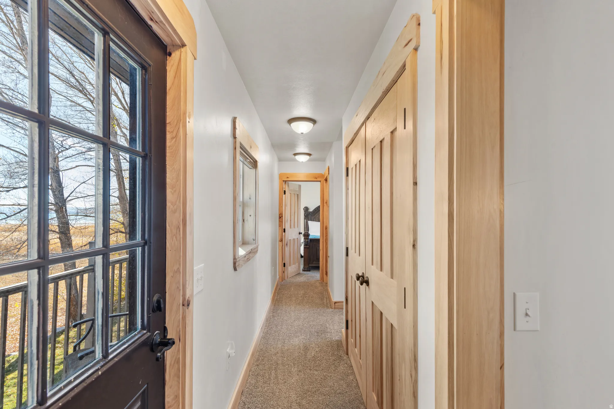 Hall featuring light colored carpet and baseboards