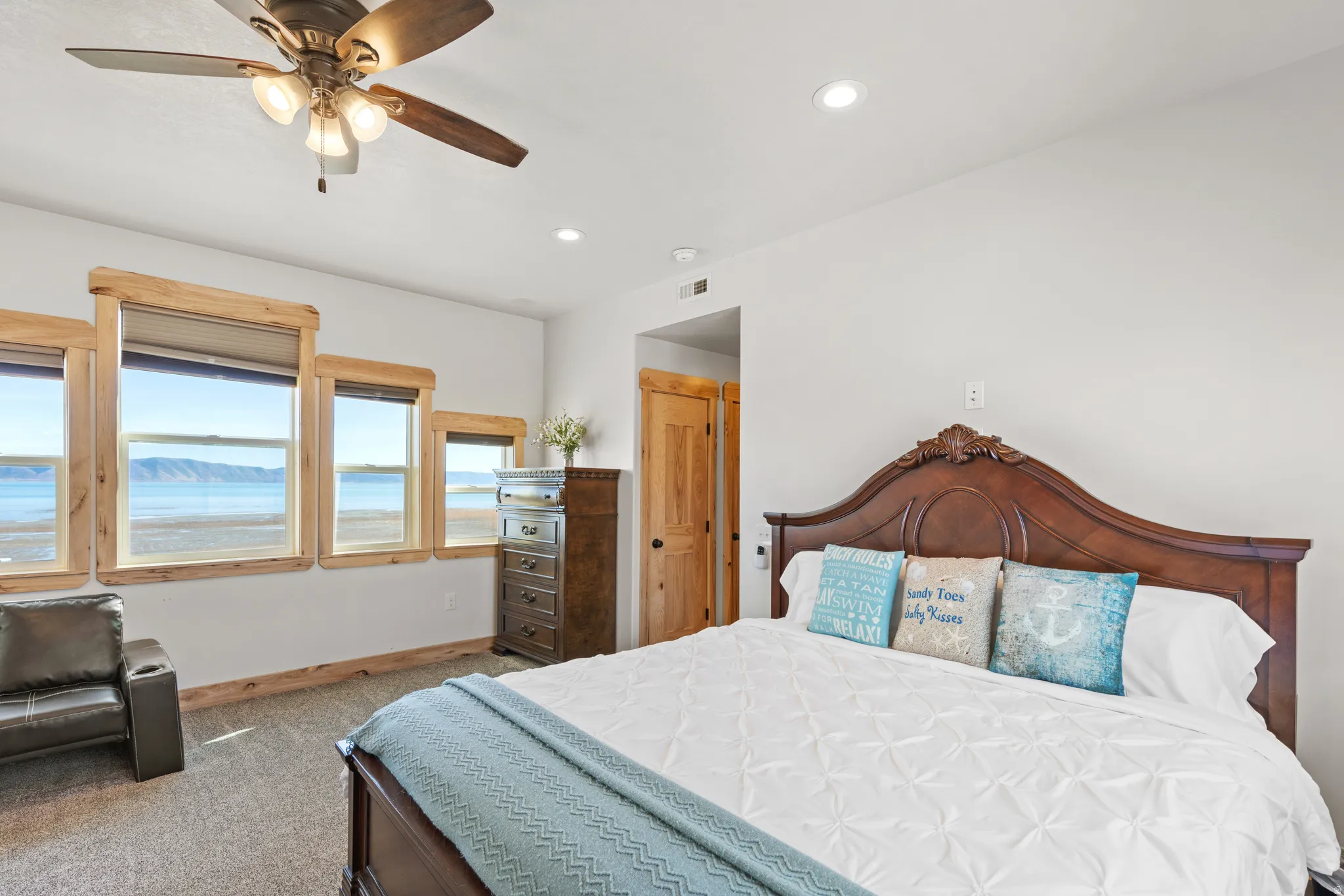 Carpeted bedroom with recessed lighting, a ceiling fan, and a water view
