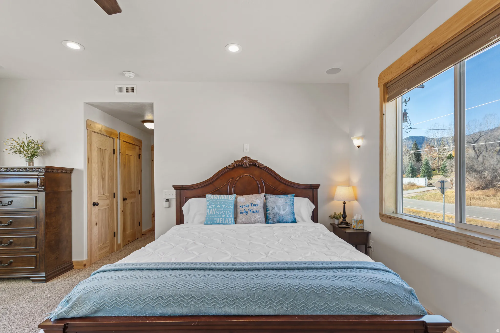 Bedroom featuring recessed lighting, a closet, a ceiling fan, light carpet, and a mountain view