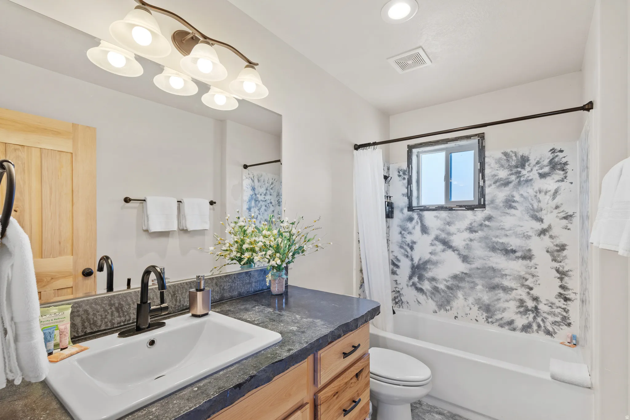 Bathroom with shower / tub combo, vanity, recessed lighting, and a chandelier