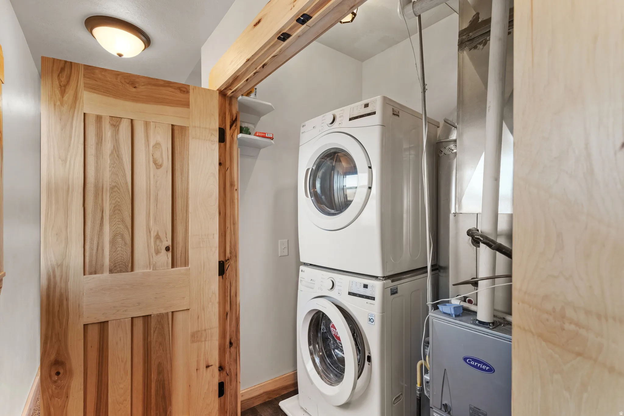 Laundry room with stacked washer / dryer and baseboards