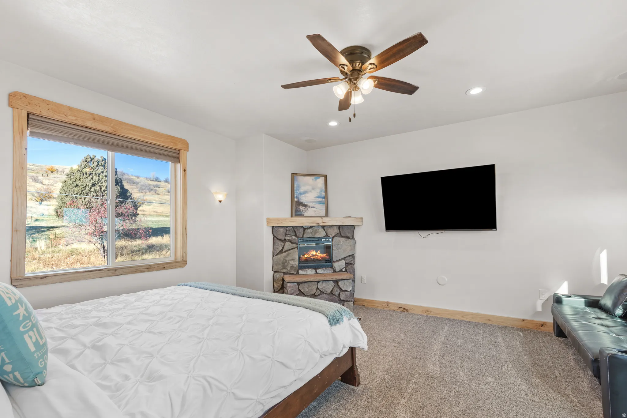 Bedroom with a stone fireplace, carpet flooring, a ceiling fan, and recessed lighting