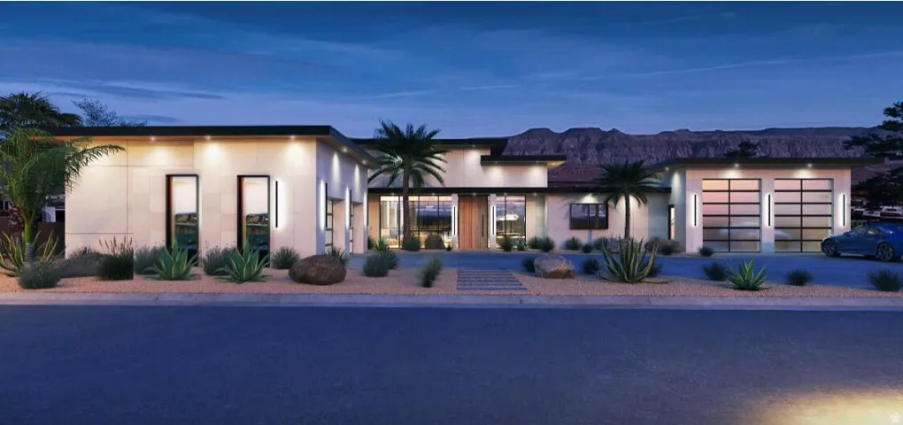 View of front of property with stucco siding, an attached garage, and driveway
