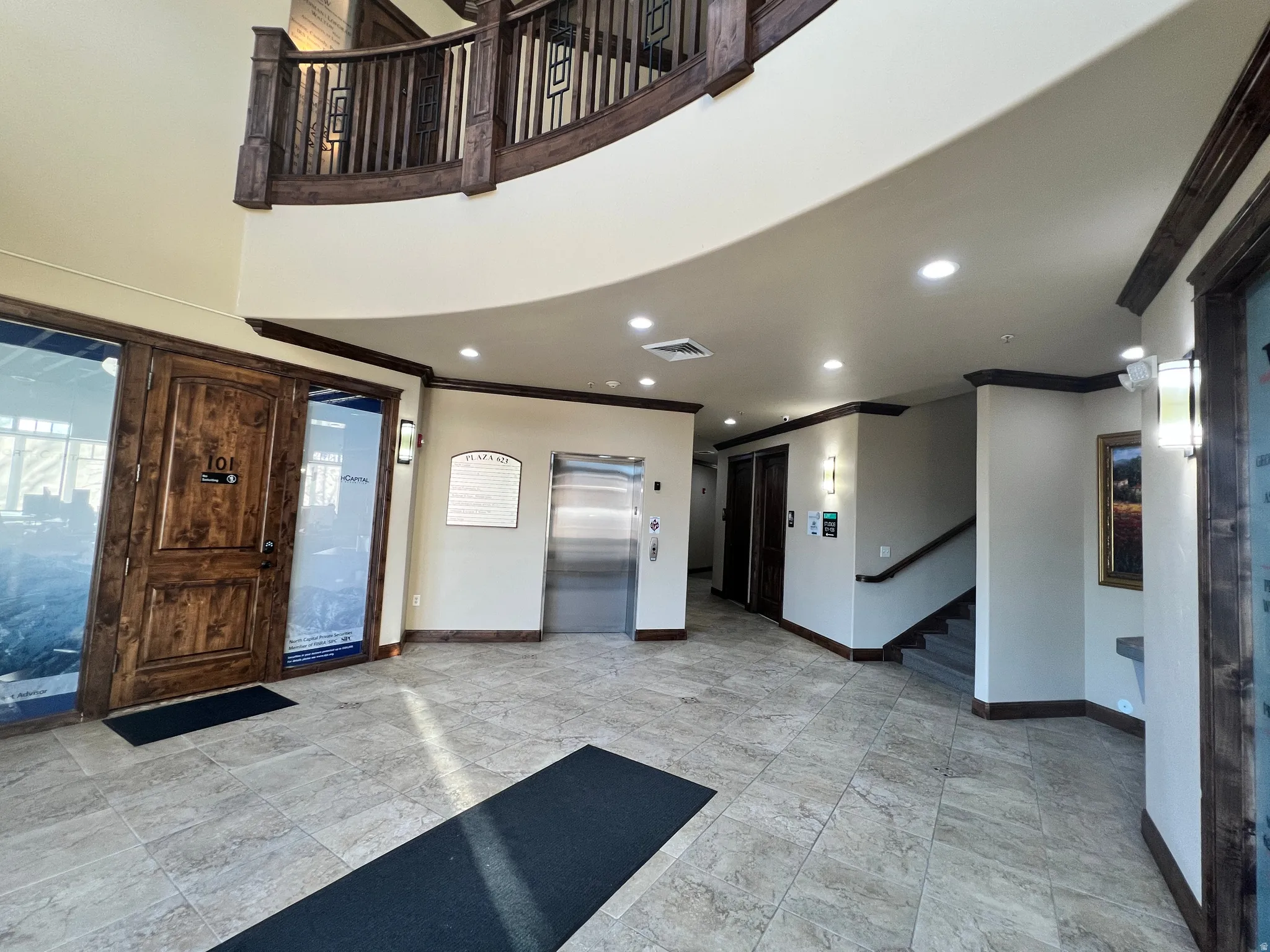 Foyer with ornamental molding, elevator, recessed lighting, stairs, and a towering ceiling