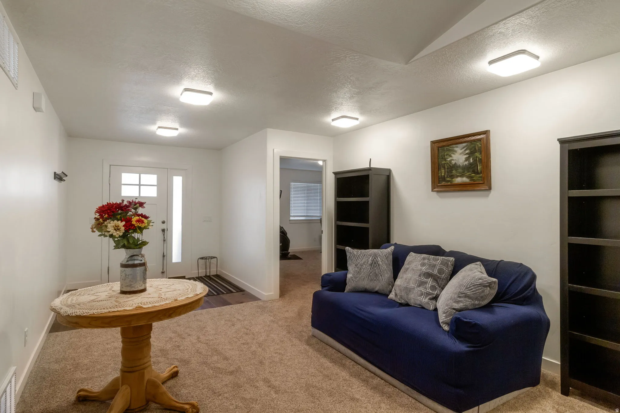 Living area with a textured ceiling and carpet