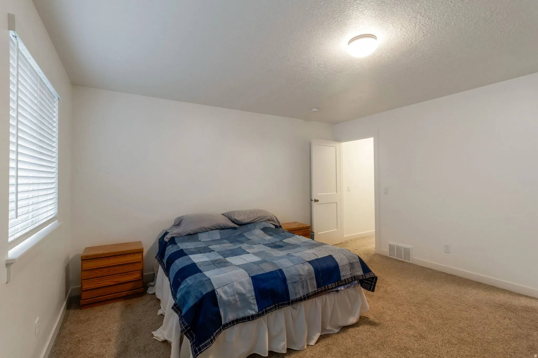 Bedroom with carpet and a textured ceiling