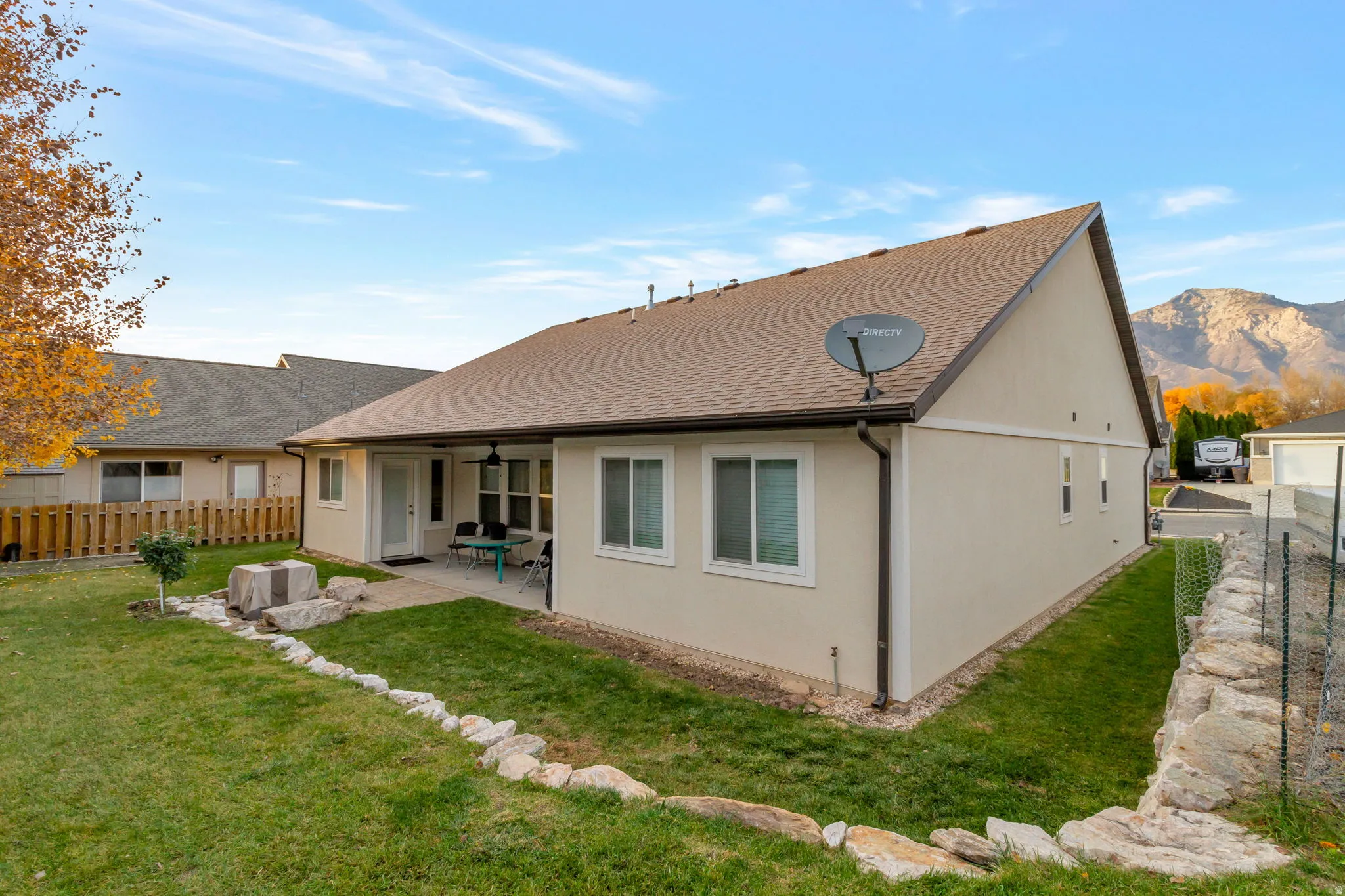 Back of house featuring a fenced backyard, a shingled roof, a patio, and stucco siding