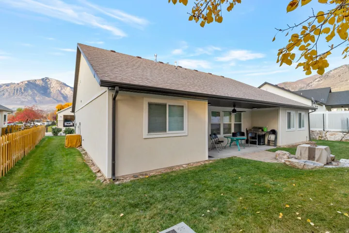Rear view of property featuring a mountain view, a fenced backyard, ceiling fan, and a patio area