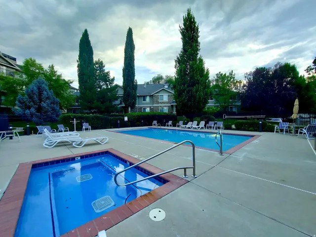 Community pool with a patio and a hot tub