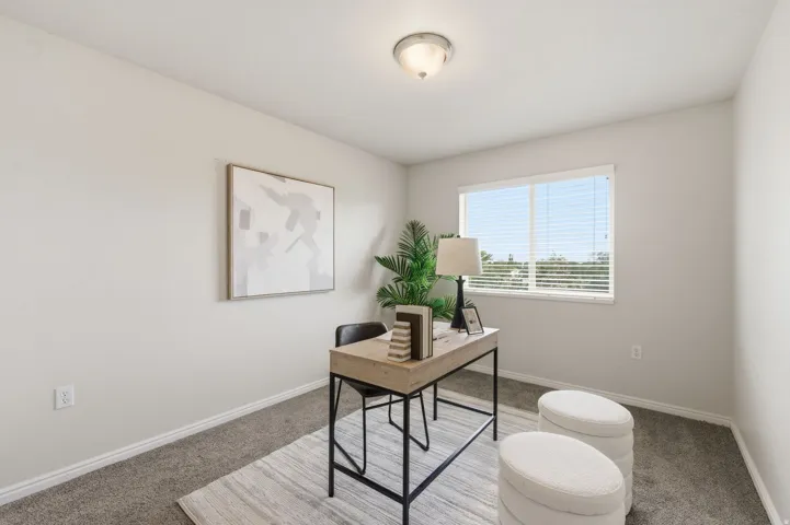 Bedroom featuring light neutral wall paint, overhead flush-mount lighting, and a large window with white blinds