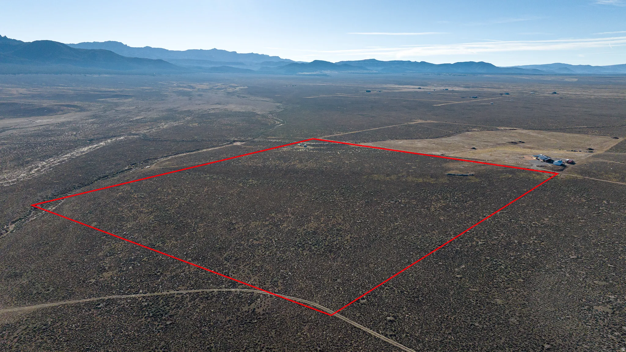 Overview of rural landscape featuring property parcel outlined and a mountainous background