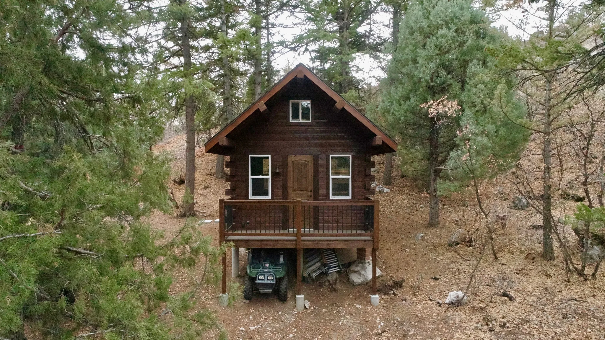 Back of property featuring a wooden deck, log siding, and a carport