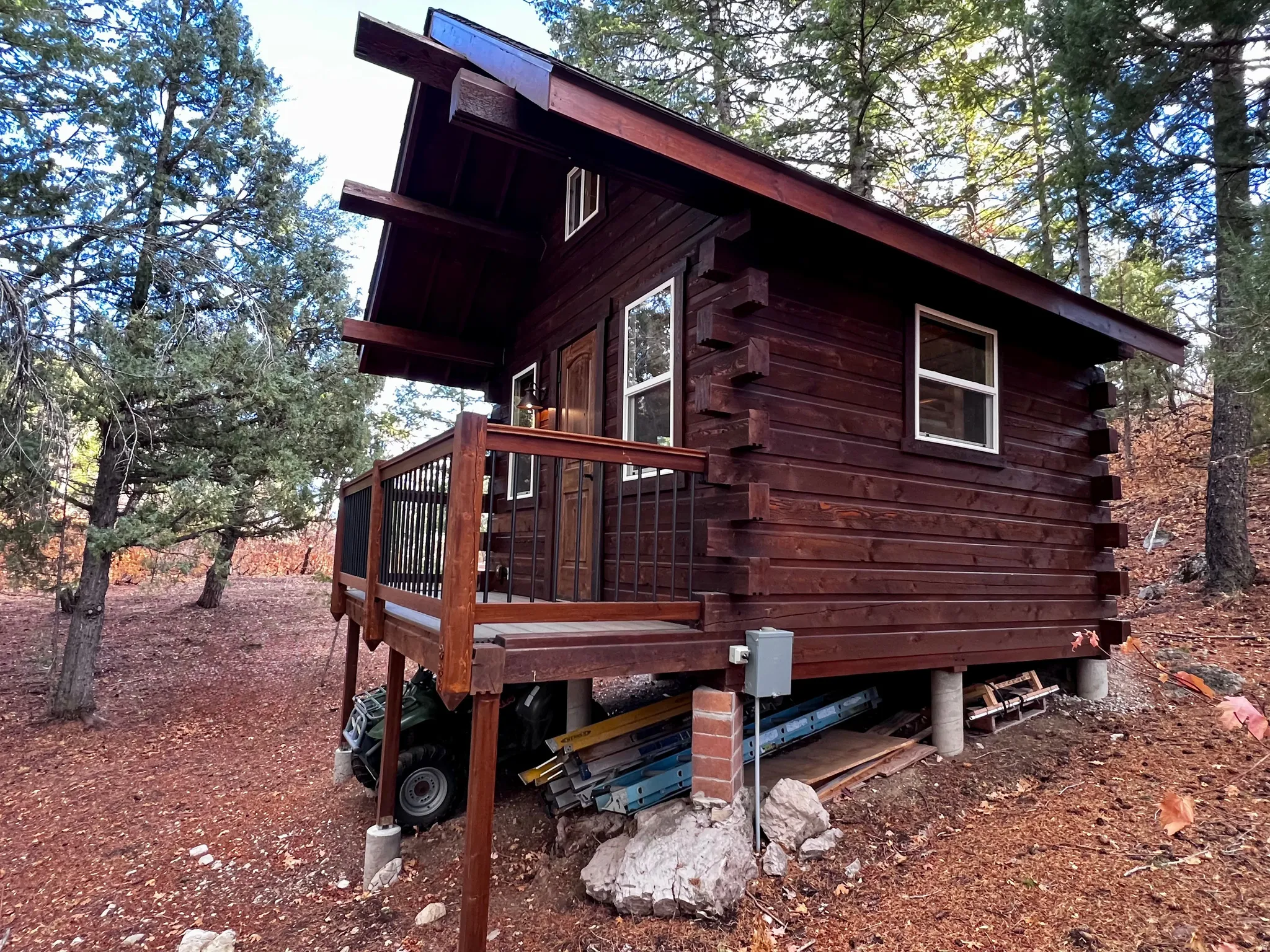 View of property exterior with log siding and a wooden deck