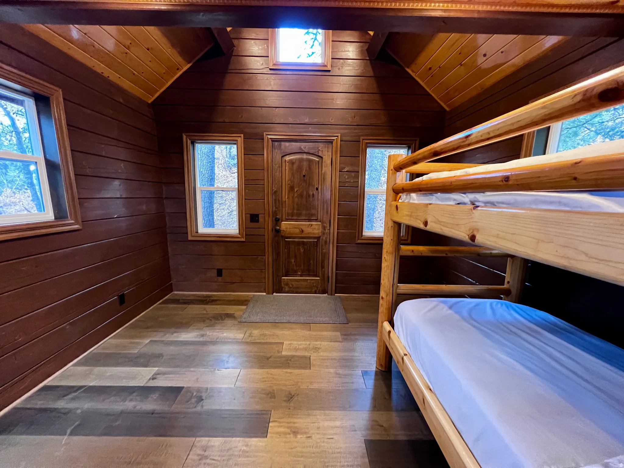 Bedroom featuring hardwood / wood-style flooring, wood walls, and wood ceiling