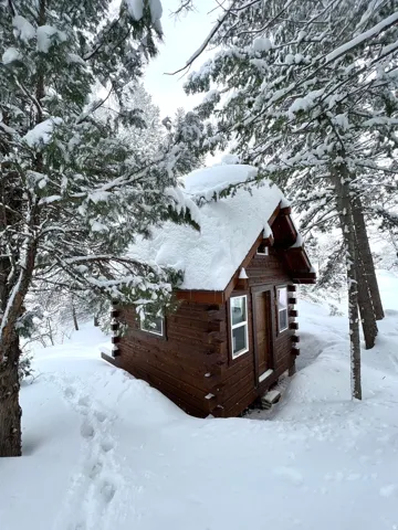 View of snowy exterior featuring log siding
