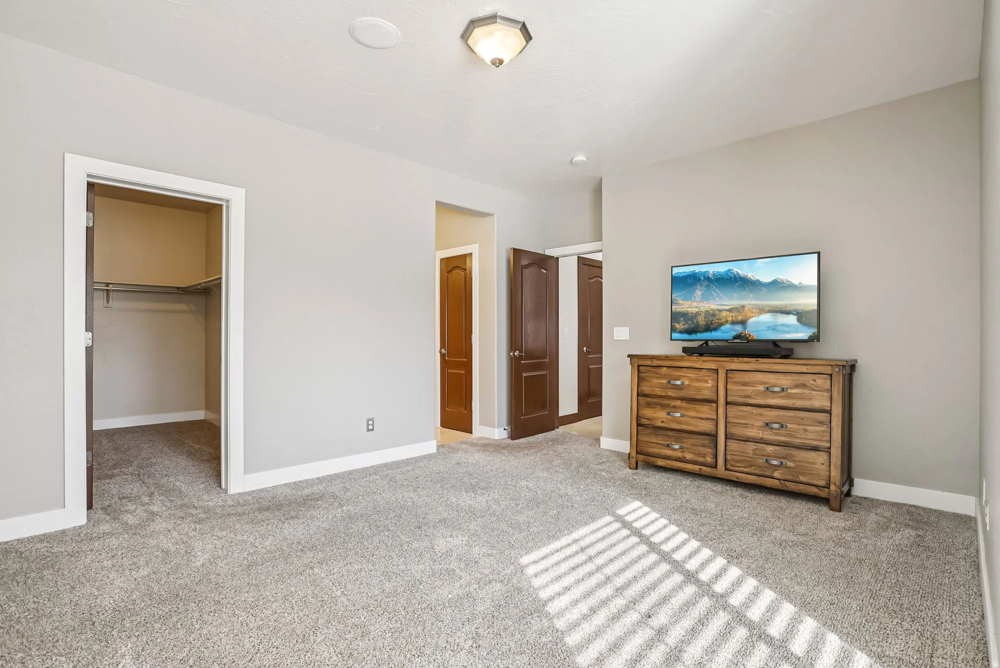 Bedroom with a spacious closet and light colored carpet