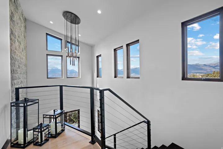 Stairway with wood finished floors, a mountain view, recessed lighting, and a chandelier