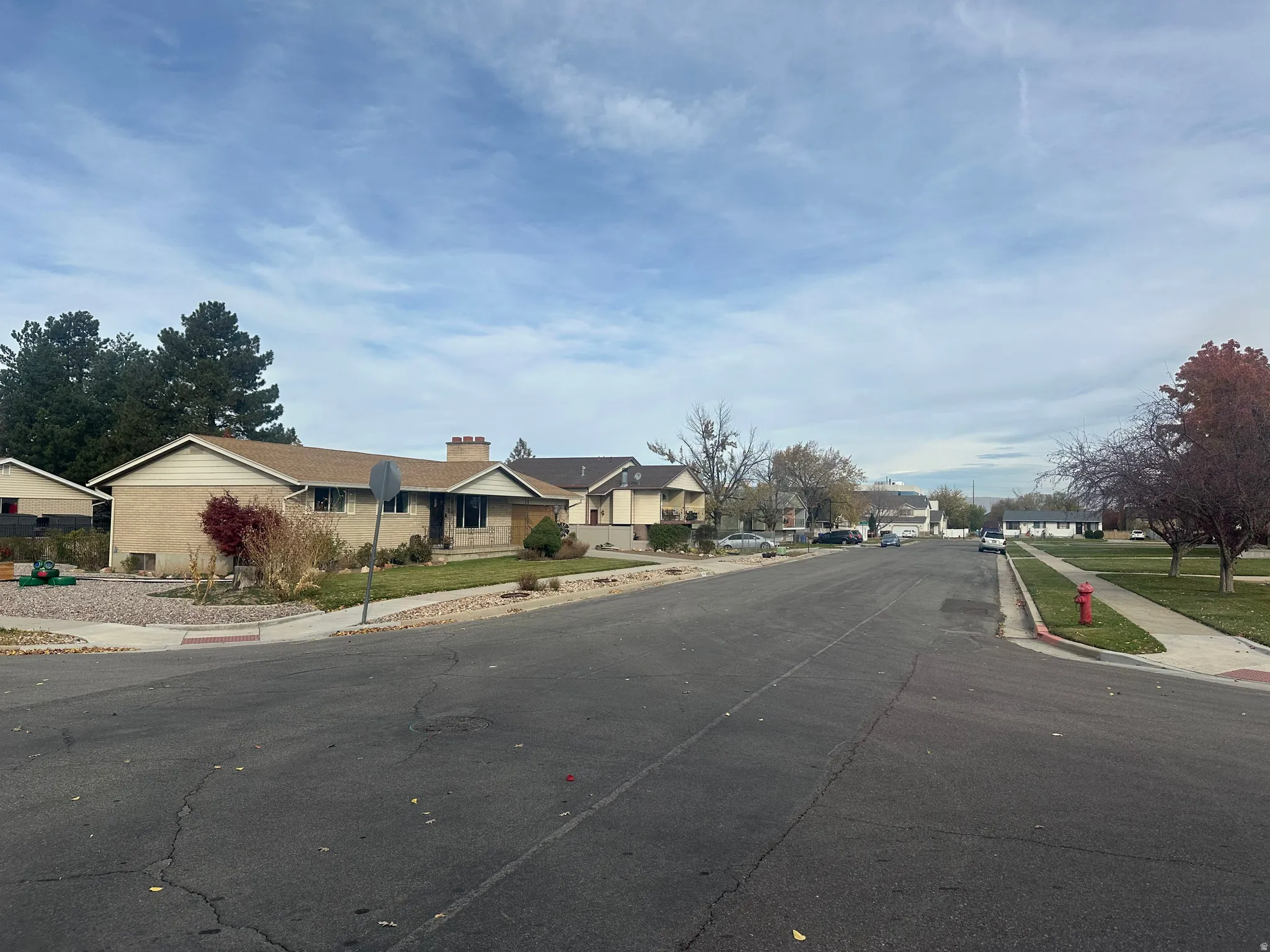 View of asphalt street featuring sidewalks, a residential view, and curbs