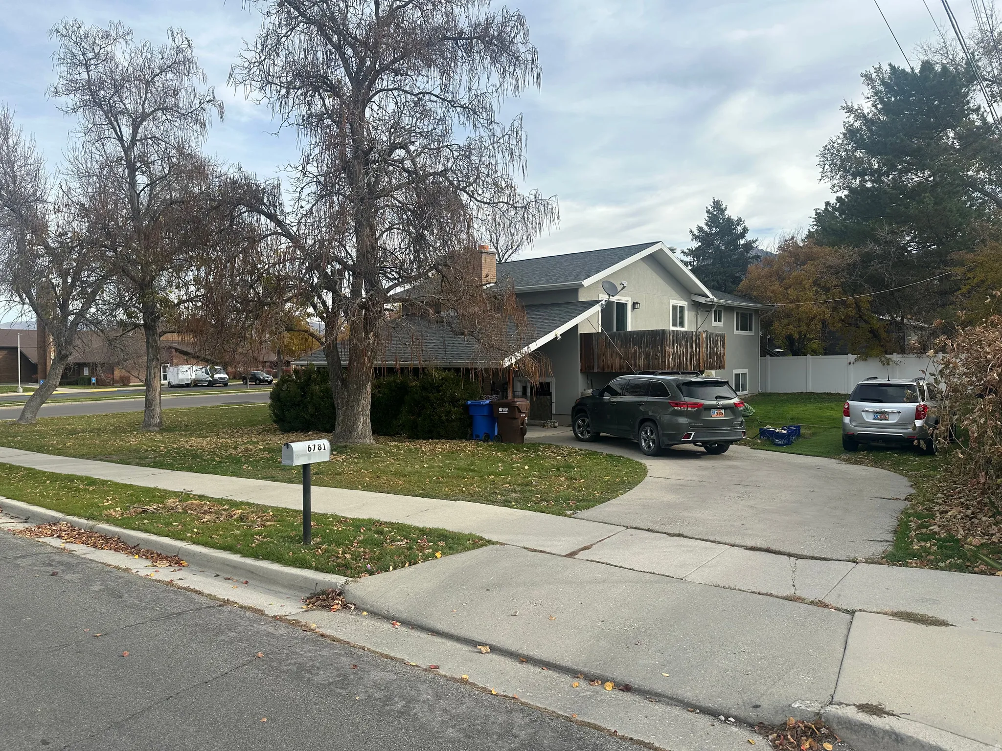 View of front of home featuring concrete driveway, a chimney, and a shingled roof