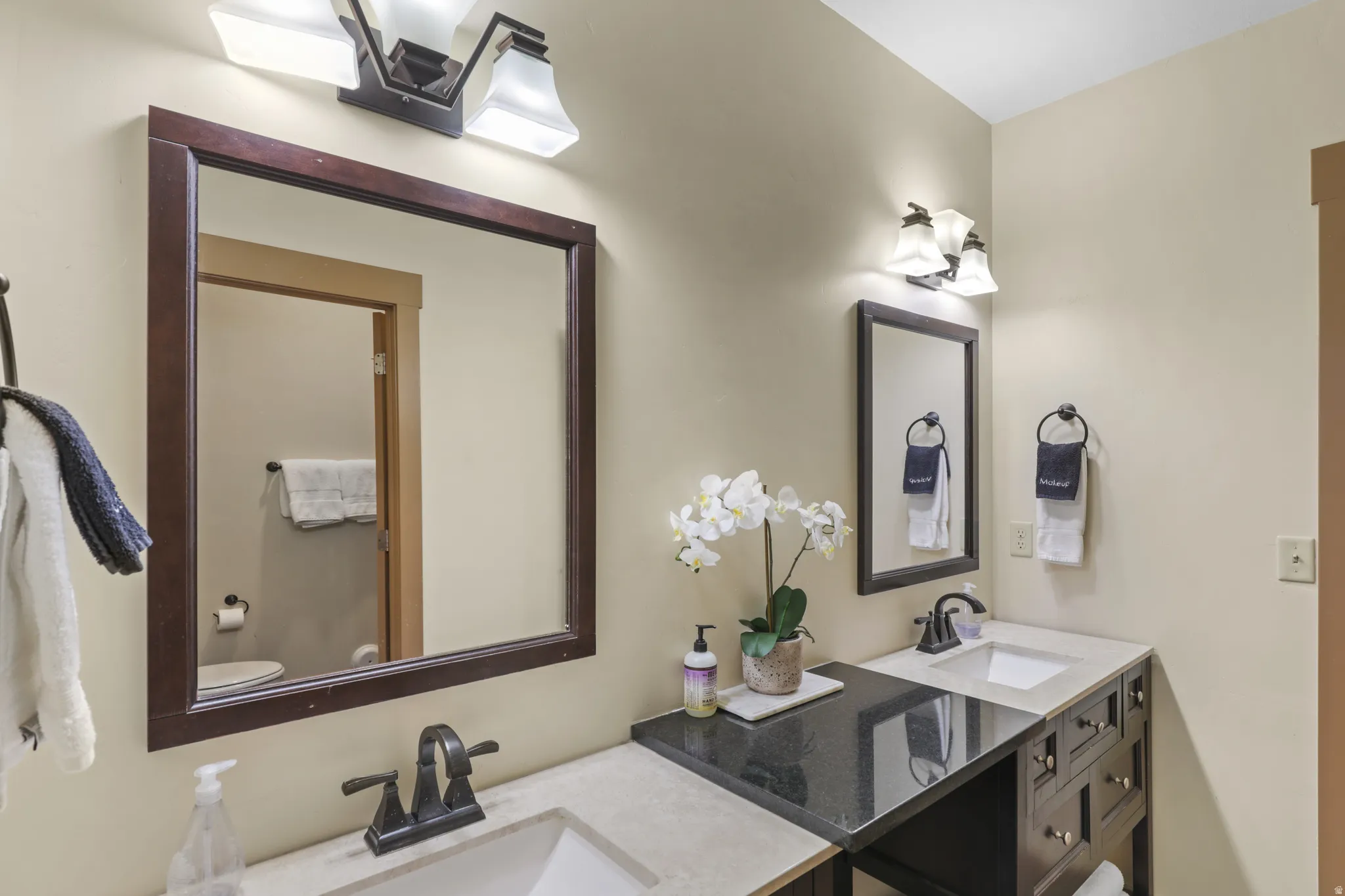 Full bathroom featuring double vanity and toilet