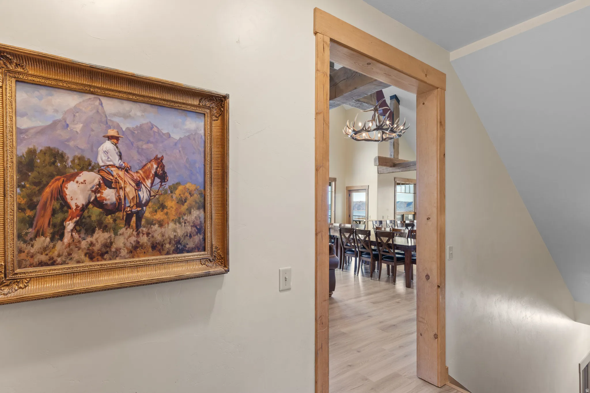 Hall with a chandelier, wood finished floors, and beam ceiling