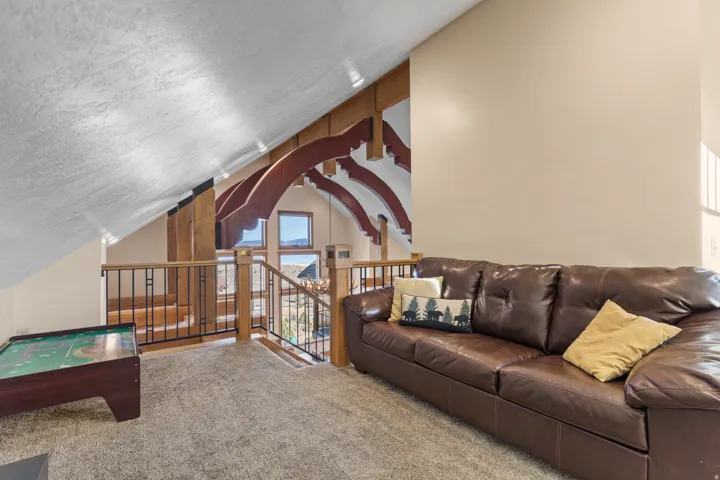 Carpeted living room featuring vaulted ceiling and a textured ceiling