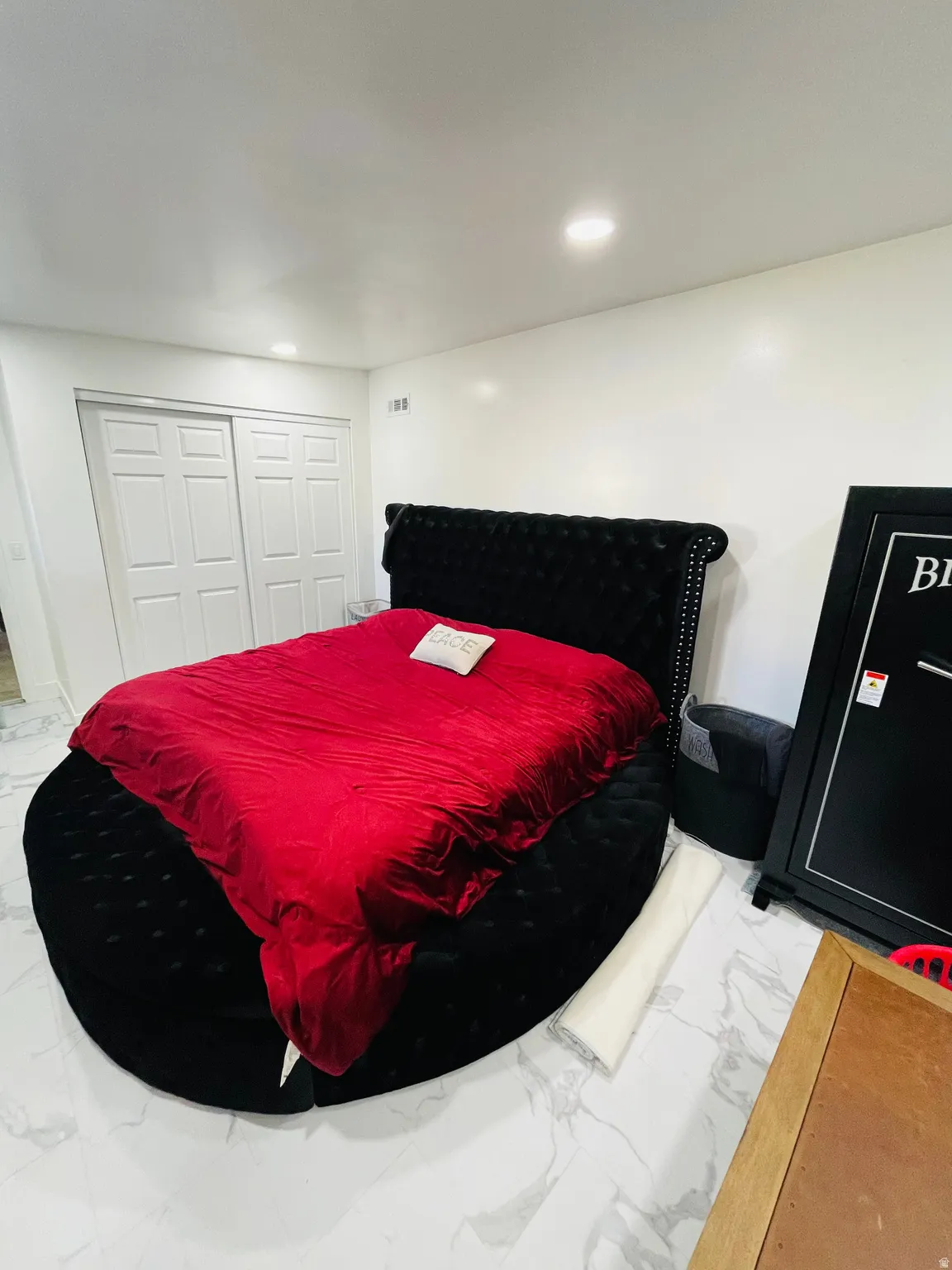 Bedroom with light marble finish floors, recessed lighting, and a closet
