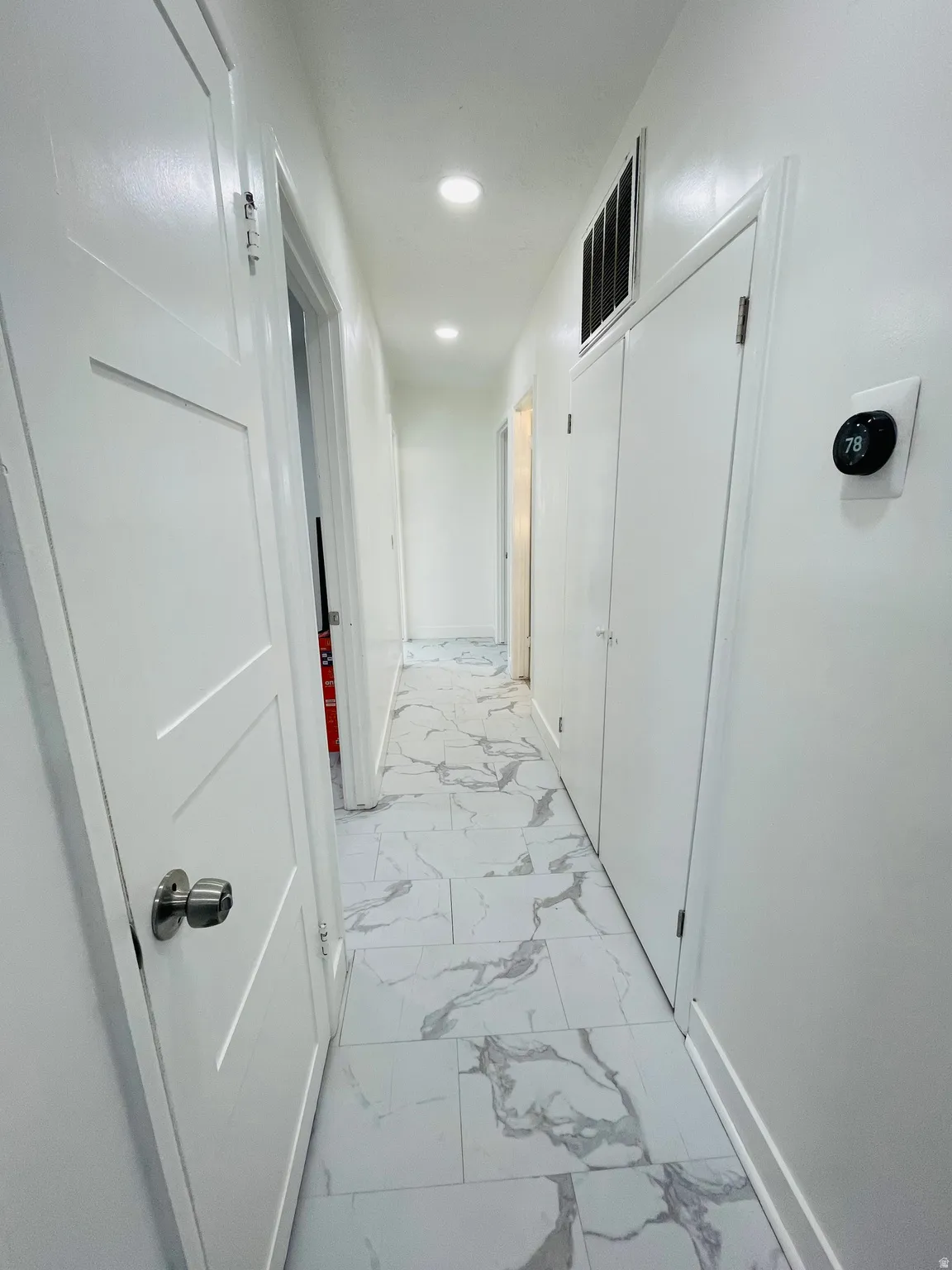 Corridor with light marble finish flooring and recessed lighting