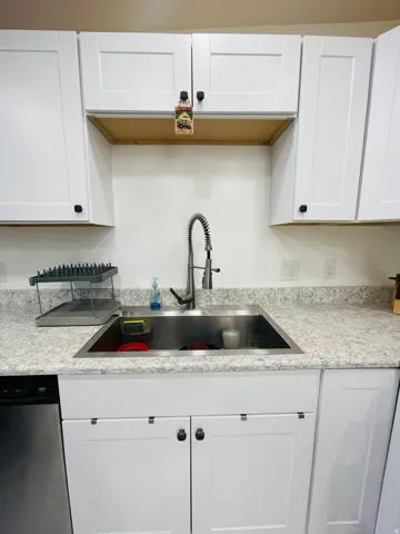 Kitchen with white cabinets and stainless steel dishwasher