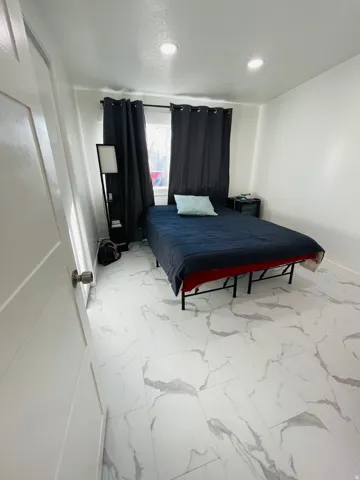 Bedroom with light marble finish flooring and recessed lighting