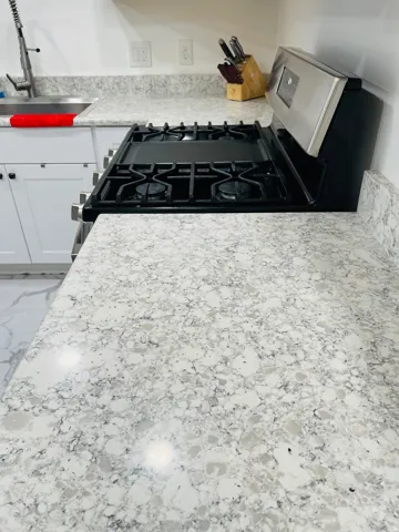 Kitchen view of gas range and white cabinetry