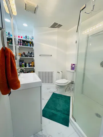 Full bathroom with vanity, a stall shower, and light marble finish floors