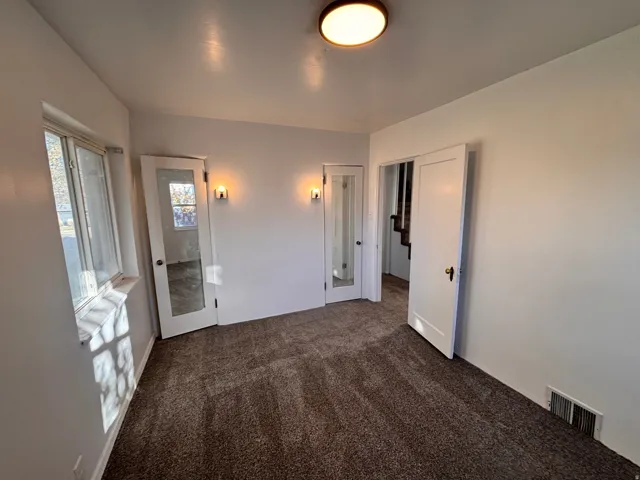 Unfurnished bedroom with dark carpet