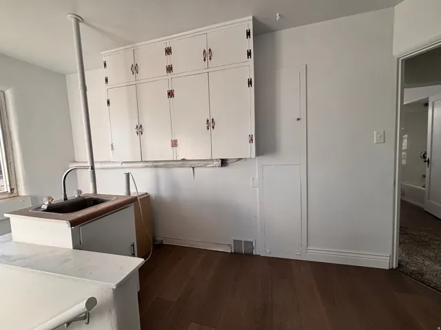 Laundry area featuring dark wood-style flooring