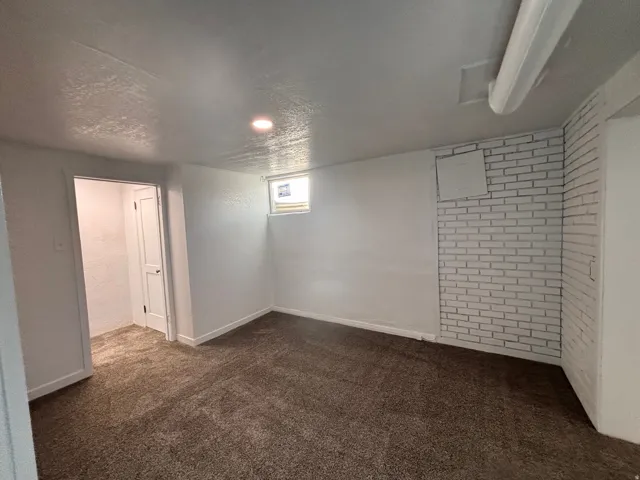 Basement with dark carpet and a textured ceiling