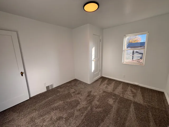 Spare room featuring dark colored carpet