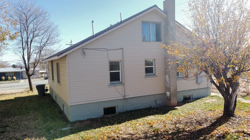 View of side of property with a chimney and a lawn
